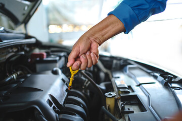 Fototapeta na wymiar Mechanic to check the oil level. Car service and maintenance concept.