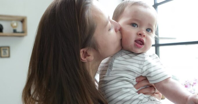 Young mother kissing her baby boy 50fps handheld