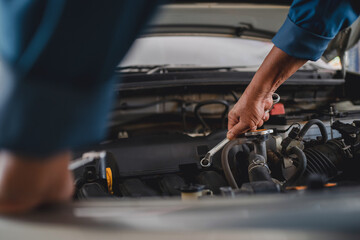 Hand of the auto mechanic was repairing the problem car, he held a wrench.