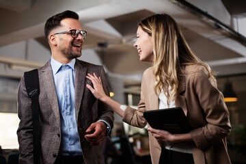 Colleagues talking in the office. Businesswoman and businessman discussing work in office..
