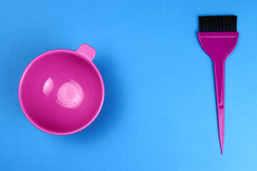 Hair dye kit pink plastic bowl and brush on a blue background