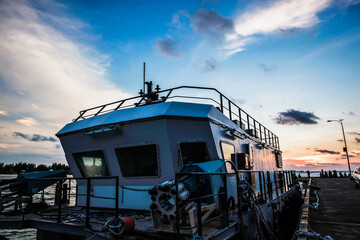 Fototapeta na wymiar A ship floating in a harbor with beautiful sky background during sunset at Karimun Jawa Island