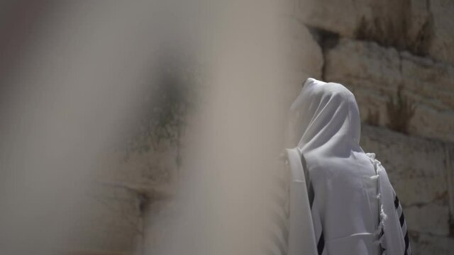 Jewish man pray alone at the wailing wall, Cotel. Strength his believe and faith to god wearing a Tallit and Tefillin. Spirituality act at the sacred holy place in Jerusalem Israel.