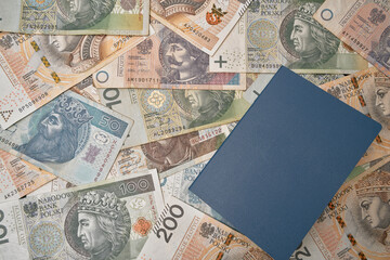 unnamed blue passport on poland national currency. no logo id document and polish zloty. banknotes...