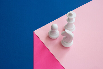 White chess pieces on a cube. Pawn, chess knight and chess queen on a bright background. Teamwork concept. Abstract background