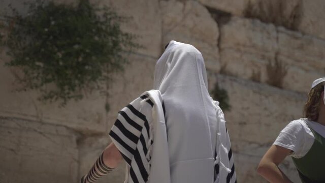Jewish man pray alone at the wailing wall, Cotel. Strength his believe and faith to god wearing a Tallit and Tefillin. Spirituality act at the sacred holy place in Jerusalem Israel.