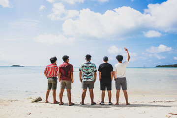 Back view of Group of friends enjoying summer vacation at tropical beach
