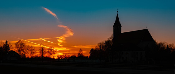 Fototapeta premium Beautiful sunset with a church silhouette near Kurzenisarhofen, Bavaria, Germany