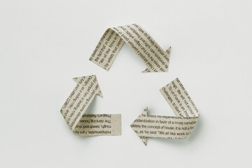 Recycle symbol made with newspaper sheet on white background - Ecology and recycling concept
