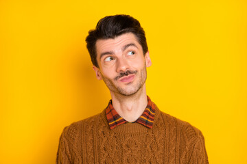 Obraz premium Photo of curious bearded young guy look empty space wear brown sweater isolated vivid yellow background