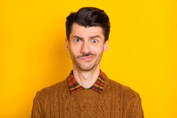 Photo of unhappy disappointed young man bad mood problem dilemma isolated on yellow color background