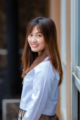 Smiling Asian student in uniform in university campus