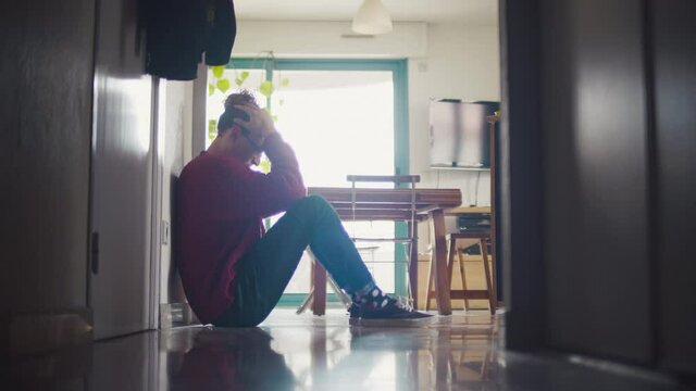 homme, triste, d&eacute;pression, personne, assis, couloir, pleure, position f&oelig;tale, pleurer, bouder, salon, maison, profile, blond, cheveux, long, boucl&eacute;e, fris&eacute;e, pull, rouge, ville, 