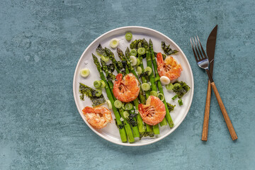 Seasonal salad from prawn shrimp, green asparagus, onion, and seaweed on a plate. Clean healthy eating.