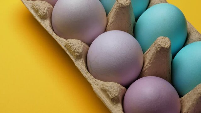 Painted easter eggs in pack. Closeup on yellow background. Rotating