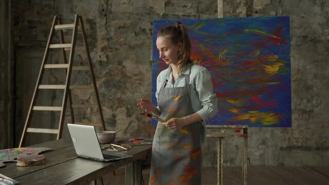 Female artist draws a picture and conducts a remote drawing training class. Woman shows that she draws, and teaches her students