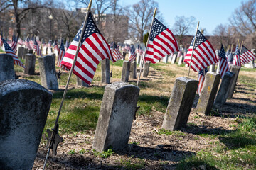 Rows of Civil War soldiers' gravestones tombstones with flags in cemetery
