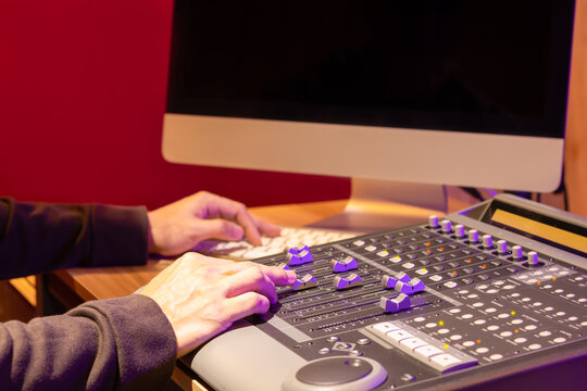 sound engineer hands mixing sound on control surface mixer for recording or live broadcasting in studio