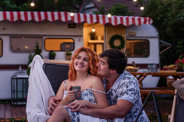 Middle-aged man proposes to a young red-haired woman. A loving couple is resting in the evening, hugging behind the countryside at the motor house. Budget Travel on Trailer Track for the weekend.