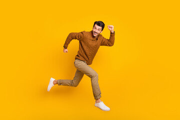Full size profile photo of optimistic nice brunet man run wear sweater isolated on yellow background