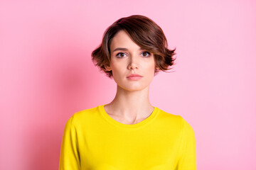 Portrait of nice attractive serious brown-haired girl wearing yellow shirt isolated over pink...