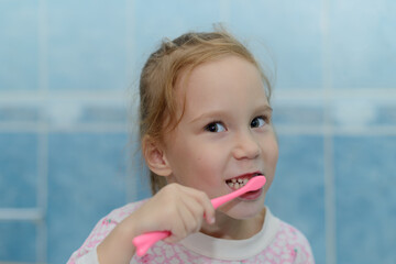 A girl of European appearance brushes her teeth