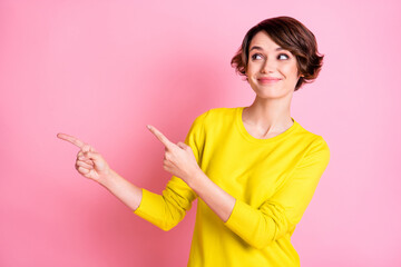 Photo of young beautiful smiling happy positive dreamy girl pointing fingers copyspace isolated on pink color background