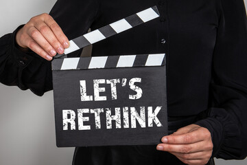 LET’S RETHINK. Movie clapper in woman hand