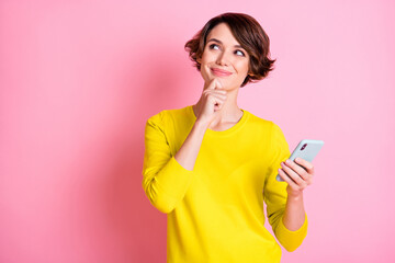 Photo portrait of happy girl curious looking blank space dreamy keeping smartphone isolated on...