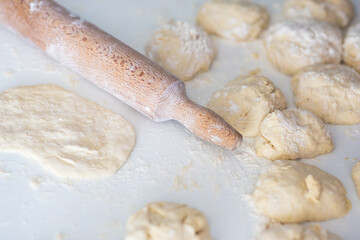 Flat lay angle view of a kitchen desk with flour, dough and roller.