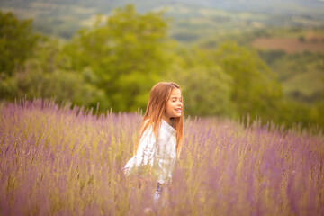 Fototapeta na wymiar Smiling little girl in lavender field.