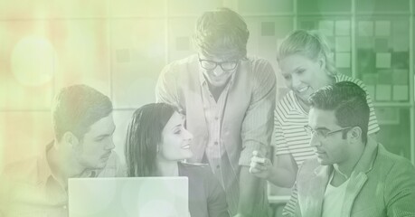 Diverse group of happy male and female colleagues working together at desk, with green yellow tint