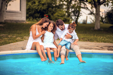 Fototapeta na wymiar Family sitting by the pool.