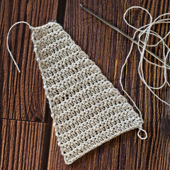 Handmade crocheted with white linen threads on a wooden table.