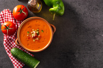 Gazpacho soup in crock pot on black stone. Top view. Copy space	