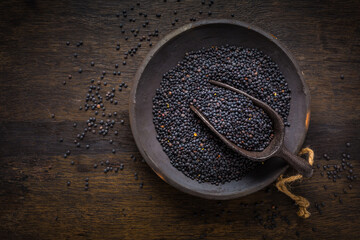Beluga lentils in bowl on dark wooden background