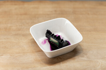 A clogged printhead from an inktjet printer being washed in a white bowl, diy repairing and...