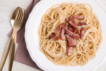 Delicious Carbonara pasta served on white wooden table, flat lay