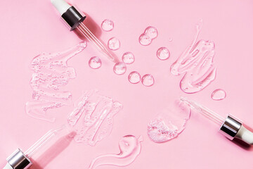 Drops of different forms of hyaluronic acid, pink background. Cosmetics concept.