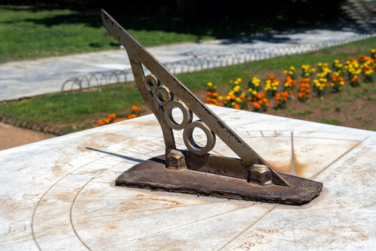 Old sundial at the National Garden public park, at the center of Athens-Greece. Antique astronomical sun clock with rusty steel gnomon dial on marble. Entrance from Vasilisis Amalias avenue, Syntagma