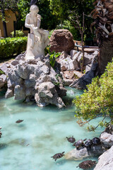 Athens, Attica, Greece. Young Fisherman marble sculpture, located at Zappeion Hall area - National Garden of Athens city. Small artificial lake, sea turtles, sunny day