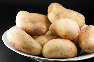 Unpeeled potatoes are on a plate