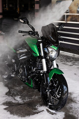 green motorcycle at the car wash under water