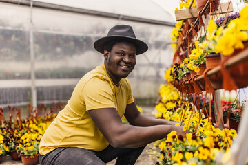 African man nurturing plants in a garden.