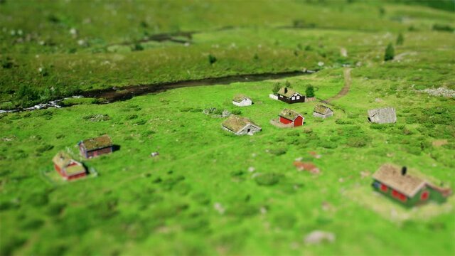 A summer flight around a sod roof house neighboring other farmers houses in Byrkjelo village captured in a juicy green valley near a powerful stream.