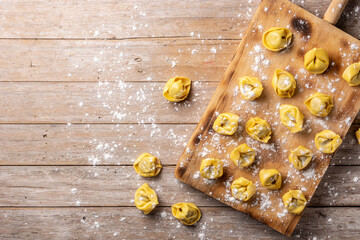 Uncooked pelmeni dumplings on rustic wooden table. typical russian food	. Top view. Copy space