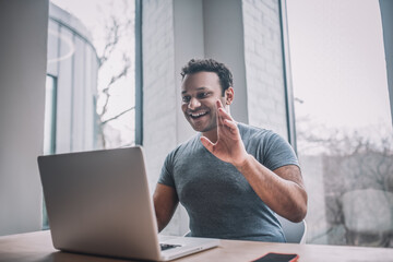 Young businessman having a video call and looking cheerful