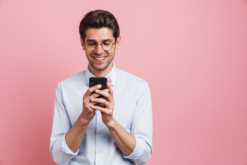 Young white man wearing eyeglasses smiling and using cellphone