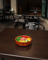 Hawaiian tuna poke bowl with vegetables on wooden table