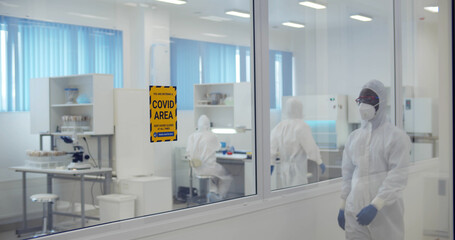 Laboratory scientist in coverall conducting research in secure high level